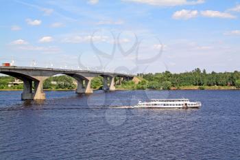 small promenade motor ship on big river near bridge