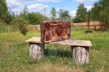 old valise near wooden bench 