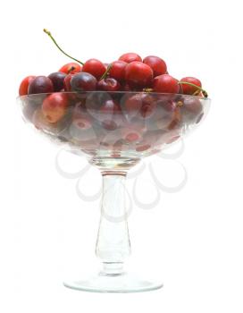 Sweet cherry fruits in a glass vase on a white background.                   