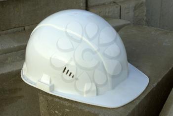 Protective building white helmet, on a against bricks.                    