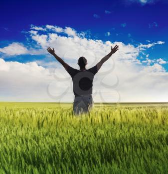 man standing on the green field under blue sky