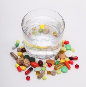 vitamins, tablets and pills and glass of water