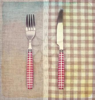 Fork and knife on napkin. Vintage retro style. Paper textured.