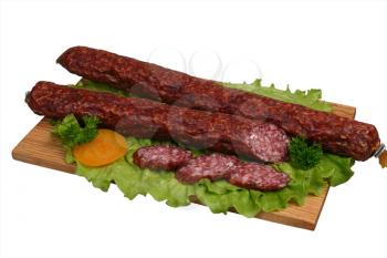 Smoked sausage with tomato and lettuce on wooden board.
