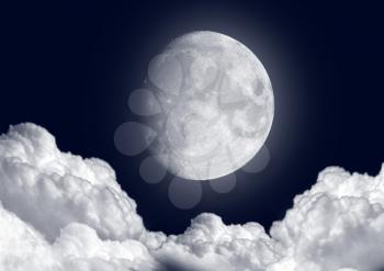 The moon in the night sky in clouds