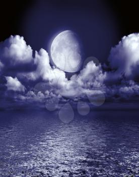 The moon in clouds reflected in water