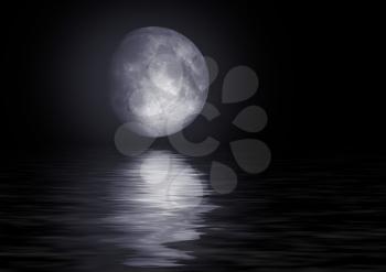 The full moon in the night sky reflected in water