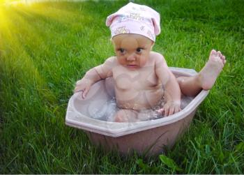 The little girl bathes in a basin