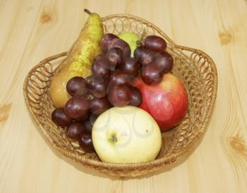 Fresh fruits on table in braided basket