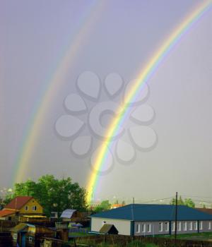 Rainbow after rain on village.Natural phenomena rainbow on sky