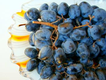 branch of green and black grapes on a plate