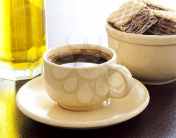 Cup of strong espresso coffee,  lemon drink and waffles on a wood table