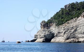 Tourist boats near the cave on the Mediterranean coast near the town of Kemer, Antalya region, Turkey.