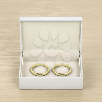 White box with gold wedding rings on wood table