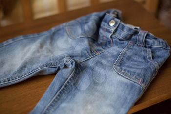 Detail of Denim blue jeans pocket on wood tabletail of Denim blue jeans pocket on wood table