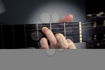 Guitar chord on a dark background with spot light