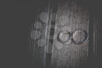 two wedding golden rings on wooden surface