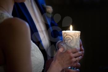 bride and groom holding a candle in church