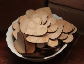 Carved wooden hearts on a white plate. Gift for Valentine's Day