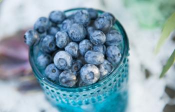 Useful blueberry berry in a vintage cup close-up