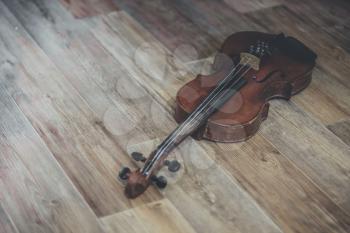 Vintage old violin lying on a wooden surface