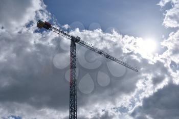 Construction crane against the sky with clouds.