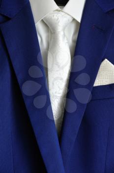 Stylish dark blue men's suit, white shirt and white tie.
