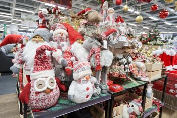 Shelf in the store with the sale of soft toys deer, santa, snowmen and owl for Christmas decoration or new year in the store with decor