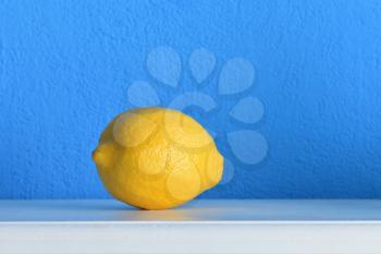 Bright and fresh lemon against a blue wall.