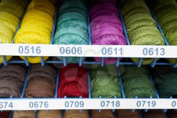 Threads for knitting different colors on the shelf in the store.