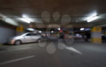 Blurred background underground parking for cars with arrows in the shopping center.