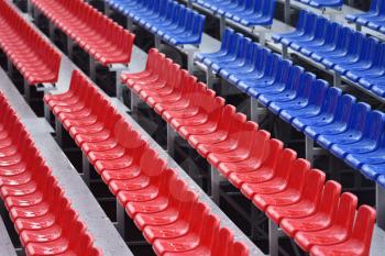Empty stands with wet seats in red, white and blue in the stadium