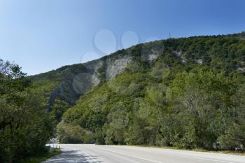 Big mountain covered with trees against the blue sky. Beautiful mountain in the vicinity of Geledzhik