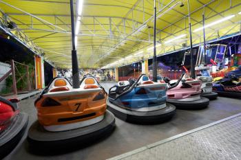 Bumper cars in the amusement park in the evening in a special pavilion.