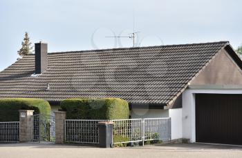 The house is located below street level and can only be seen on its tiled roof