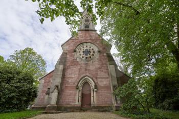 Beautiful and old Evangelical church surrounded by green bushes and trees in the European country, Baden Baden