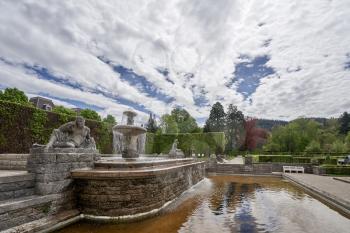 Beautiful classic public city park with a fountain, flowers and statues in the German city of Baden Baden