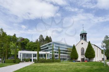 Modern Spa center salon surrounded by trees and greenery next to the Christian church in the European city of Baden Baden