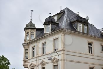 Beautiful exterior of the upper floor with a roof of a residential building in Europe