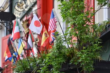 Small flags of different countries on the balcony of one of the houses in Europe. Flags of different countries, America, Japan, Germany, England, Ukraine