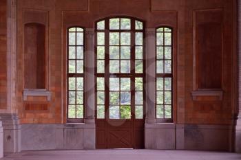 Beautiful and old large full-wall glass window with a door and access to the garden.