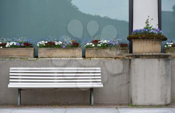 Bright bench and flowers at the facade of a building in a European city.