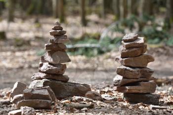 A small cairn made by tourists in the forest against a background of trees