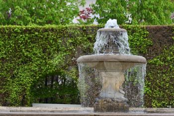 Antique water fountain in a public park of a European city
