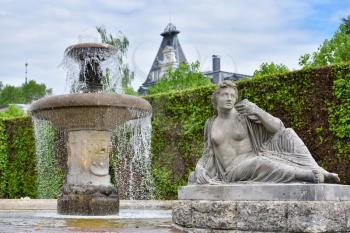 Antique fountain with water and sculptures in a public park of a European city