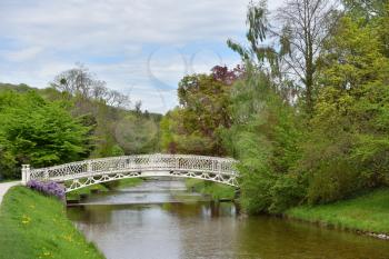A beautiful white wrought iron bridge over a river in the European city of Baden Baden. Landscape with a bridge over a river