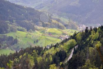 Picturesque landscape, a road on a mountainside overlooking a valley with houses in the German Forest Schwarzwald, European nature.