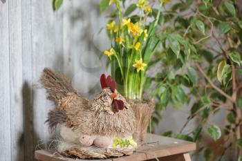 Easter decorations in a rustic photo studio. Toy chicken and eggs