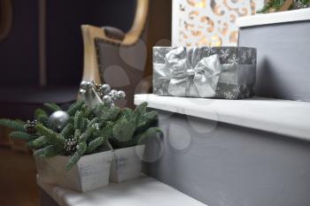 Christmas present in silver packaging with a bow, lies on the steps in the housent