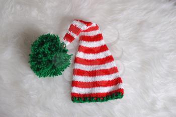 Cute children's knitted hat on a white carpet background